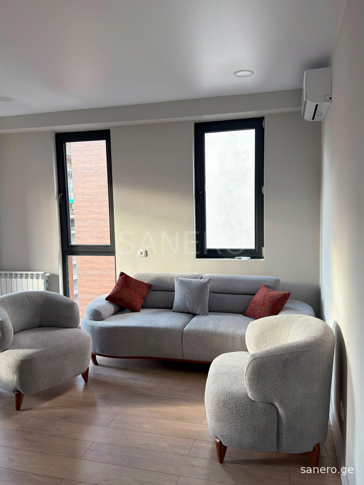 Living room with sofa, armchairs and air conditioner