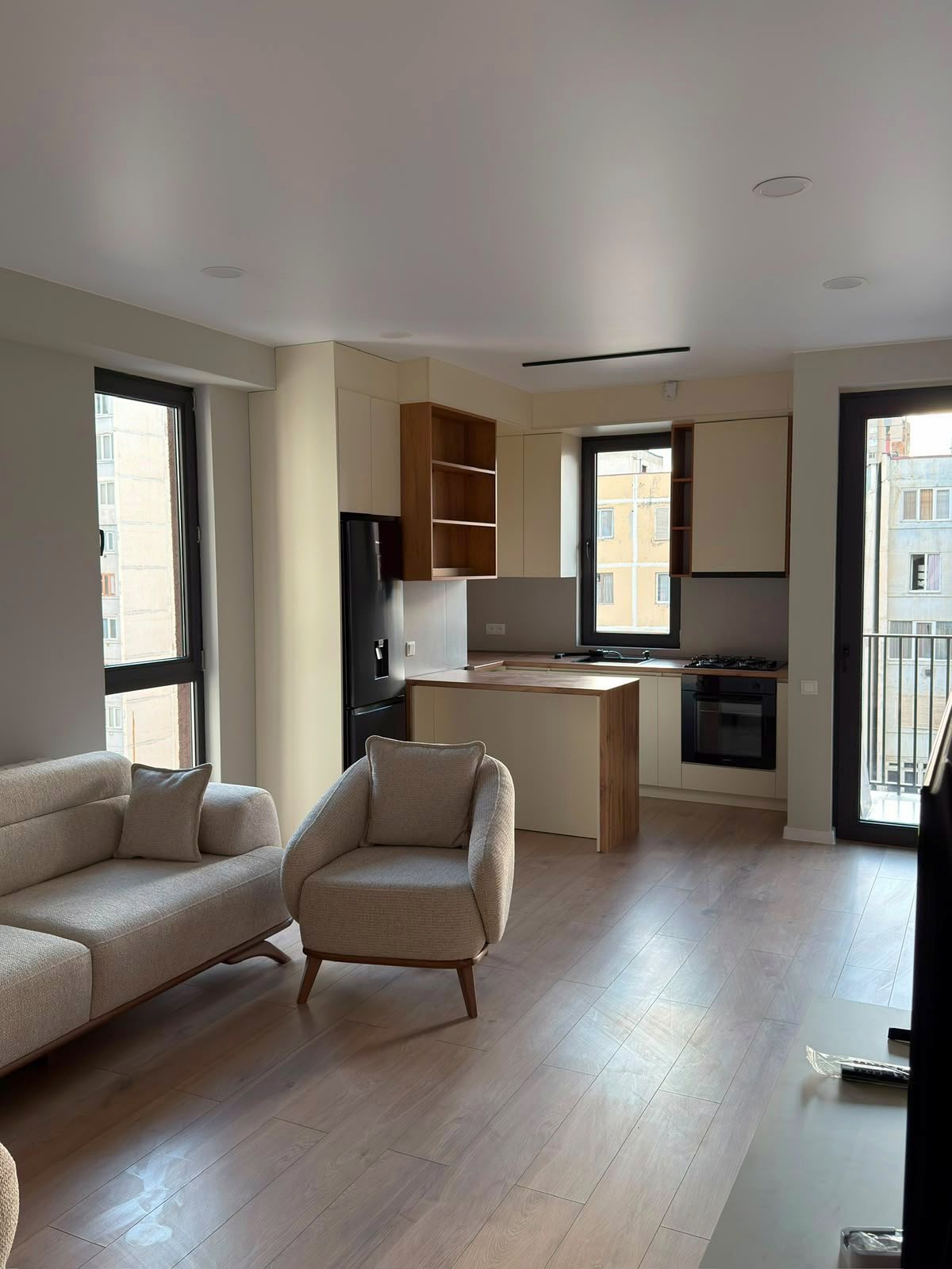 Living room with open kitchen and balcony door