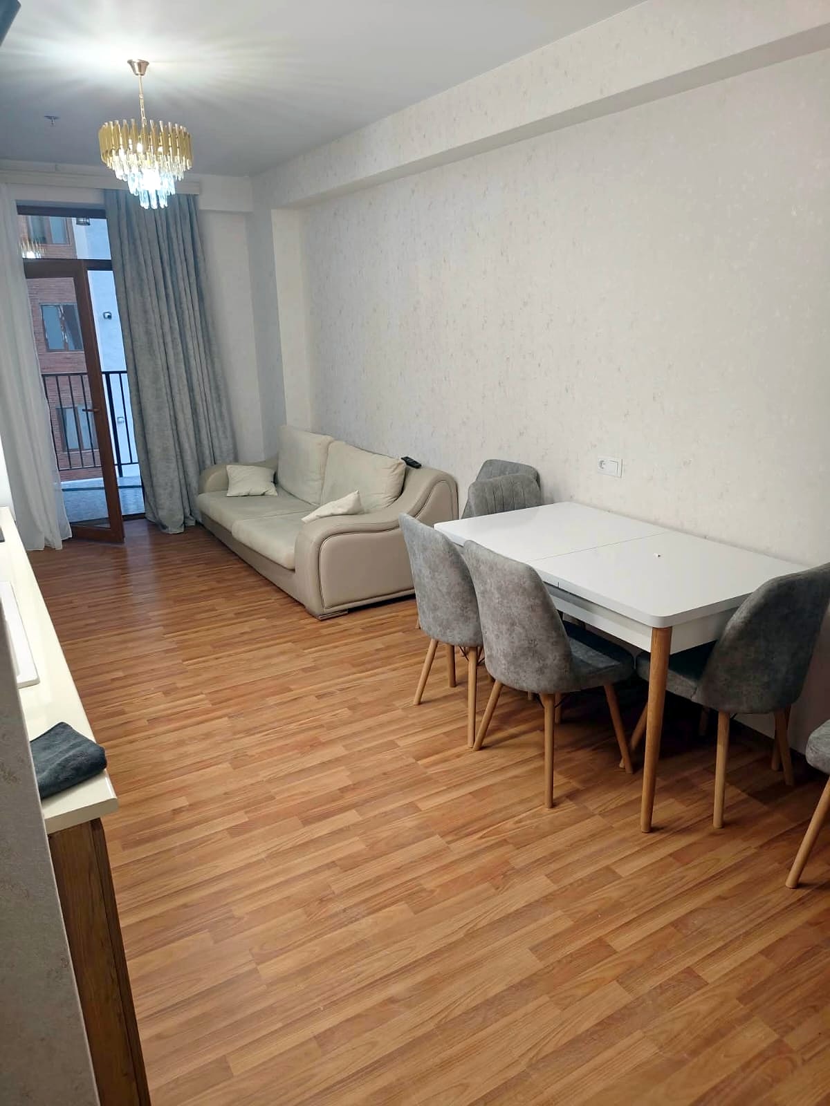Living room with sofa, dining table and balcony door