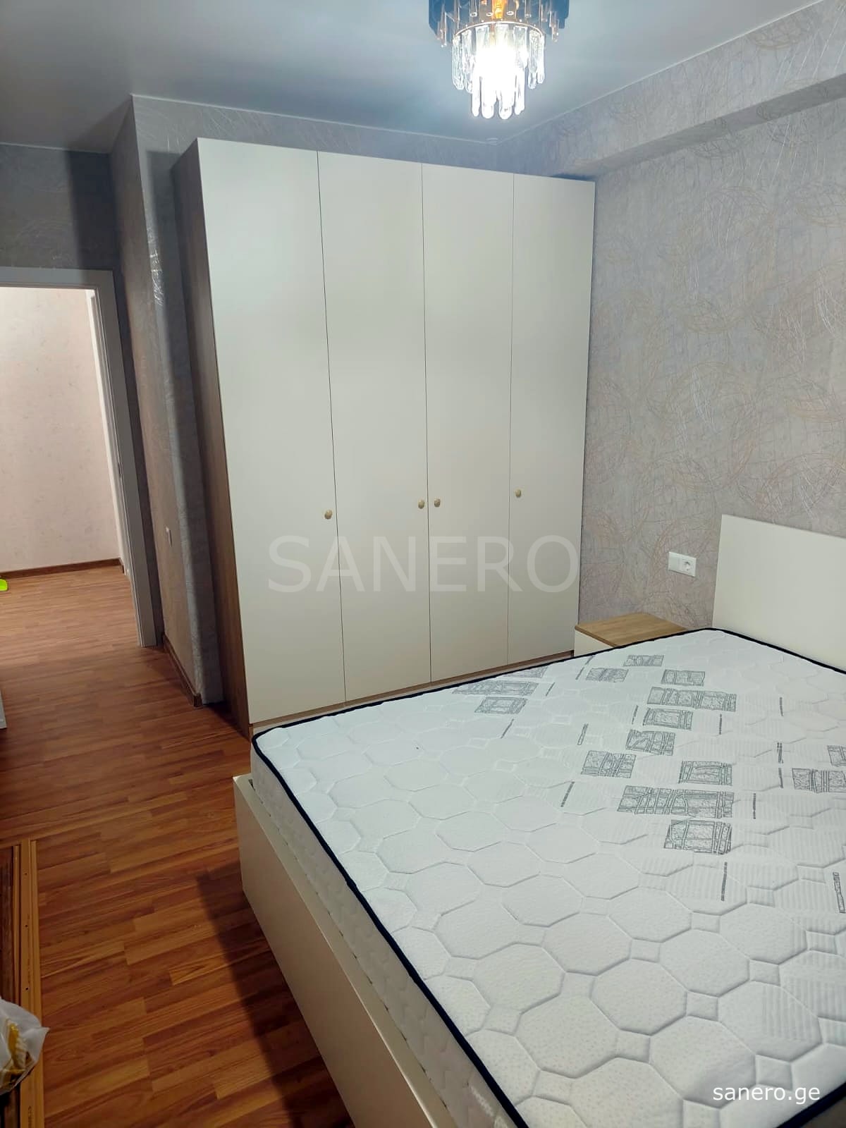Bedroom with double bed and four-door wardrobe
